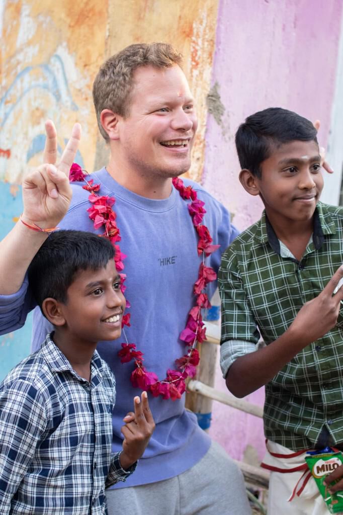 Garlanded and posing with two schoolboys