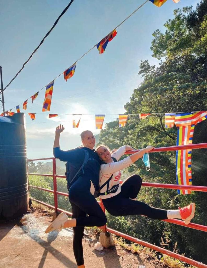 Two travellers at a hilltop viewpoint hung with Buddhist flags