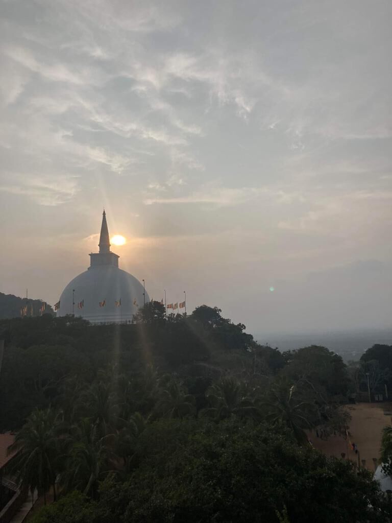The sun setting behind a white stupa at Anuradhapura