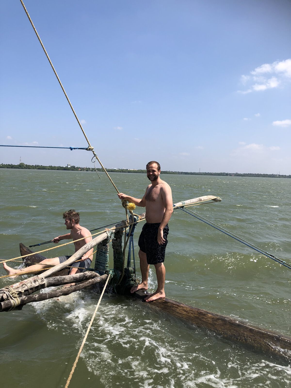 On the outrigger of a fishing boat under sail